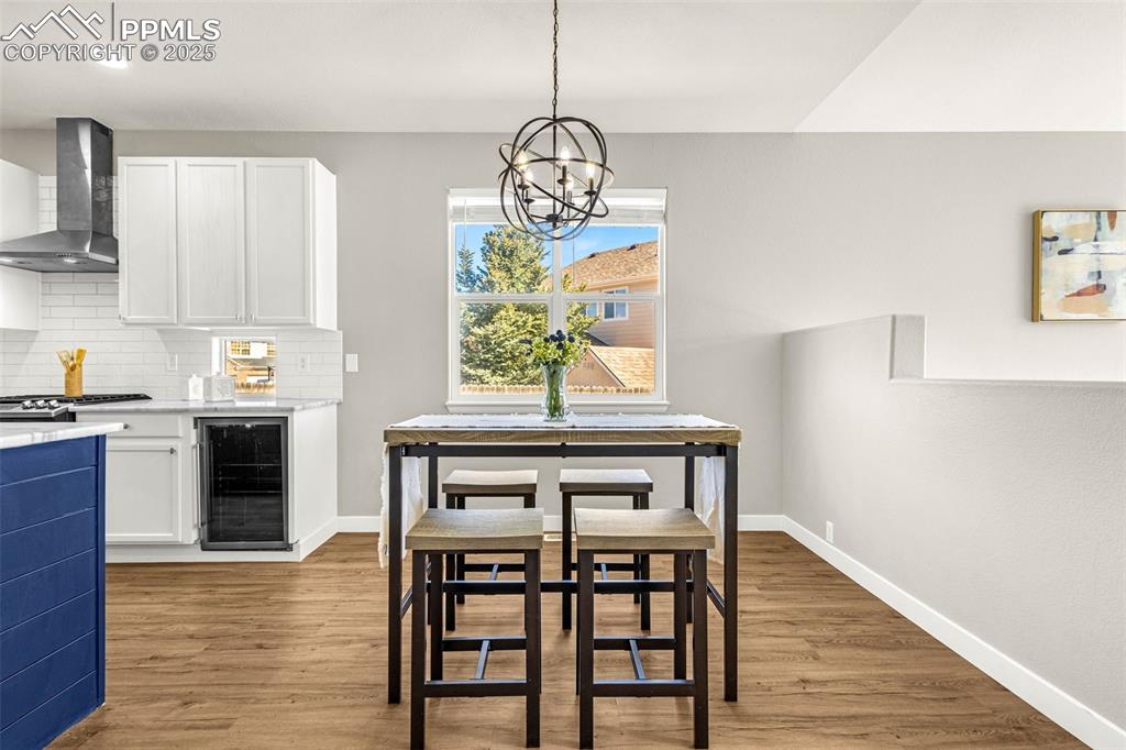 12383 Pine Valley Circle Peyton, CO 80831 - Photo 24 of 45 a kitchen with stainless steel appliances a dining table chairs and wooden floor