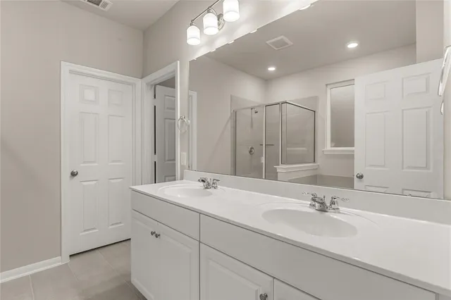 a bathroom with double sink and a mirror