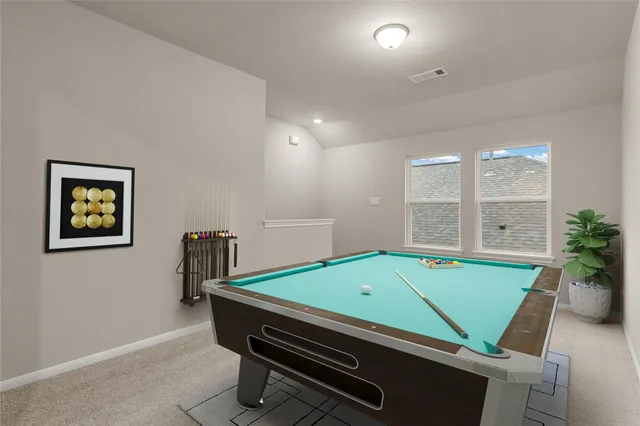 a room with pool table and windows