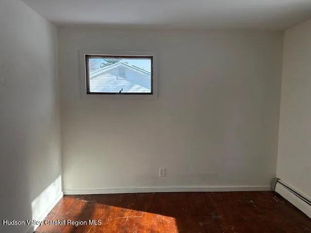 a view of small space with wooden floor and a window