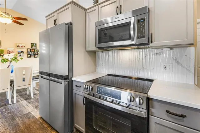 a kitchen with stainless steel appliances granite countertop a sink dishwasher and cabinets with wooden floor