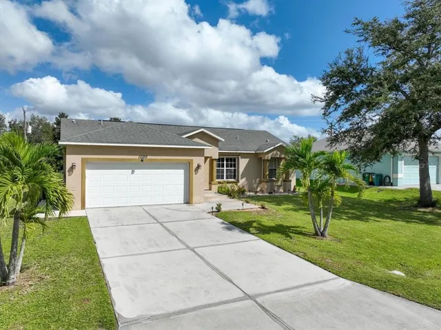 an aerial view of a house with a garden and lake view
