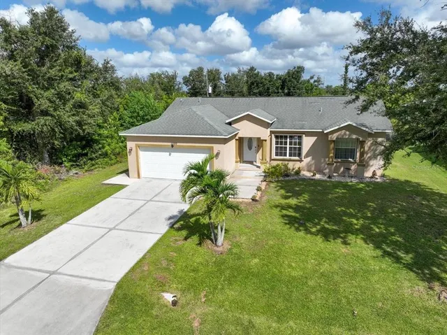 an aerial view of a residential houses with yard