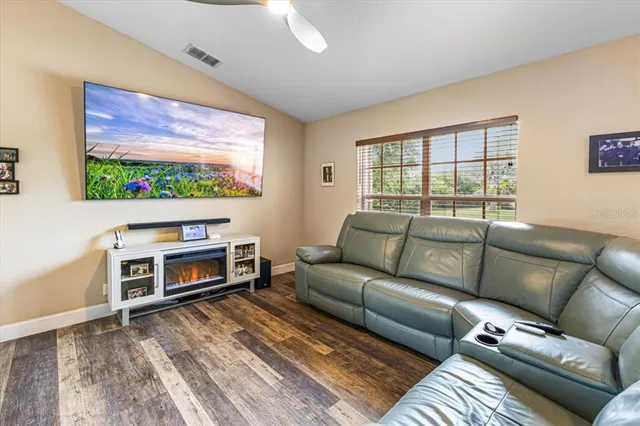 a living room with furniture a flat screen tv and a large window