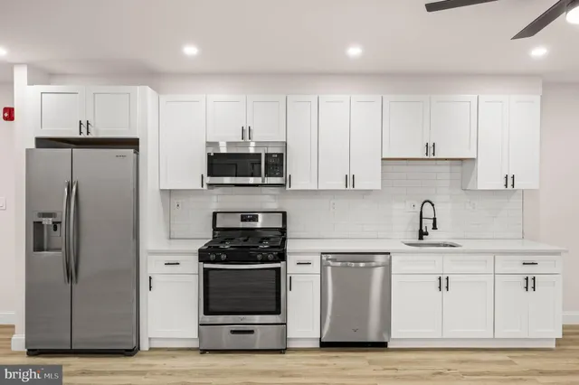 a kitchen with granite countertop white cabinets and stainless steel appliances