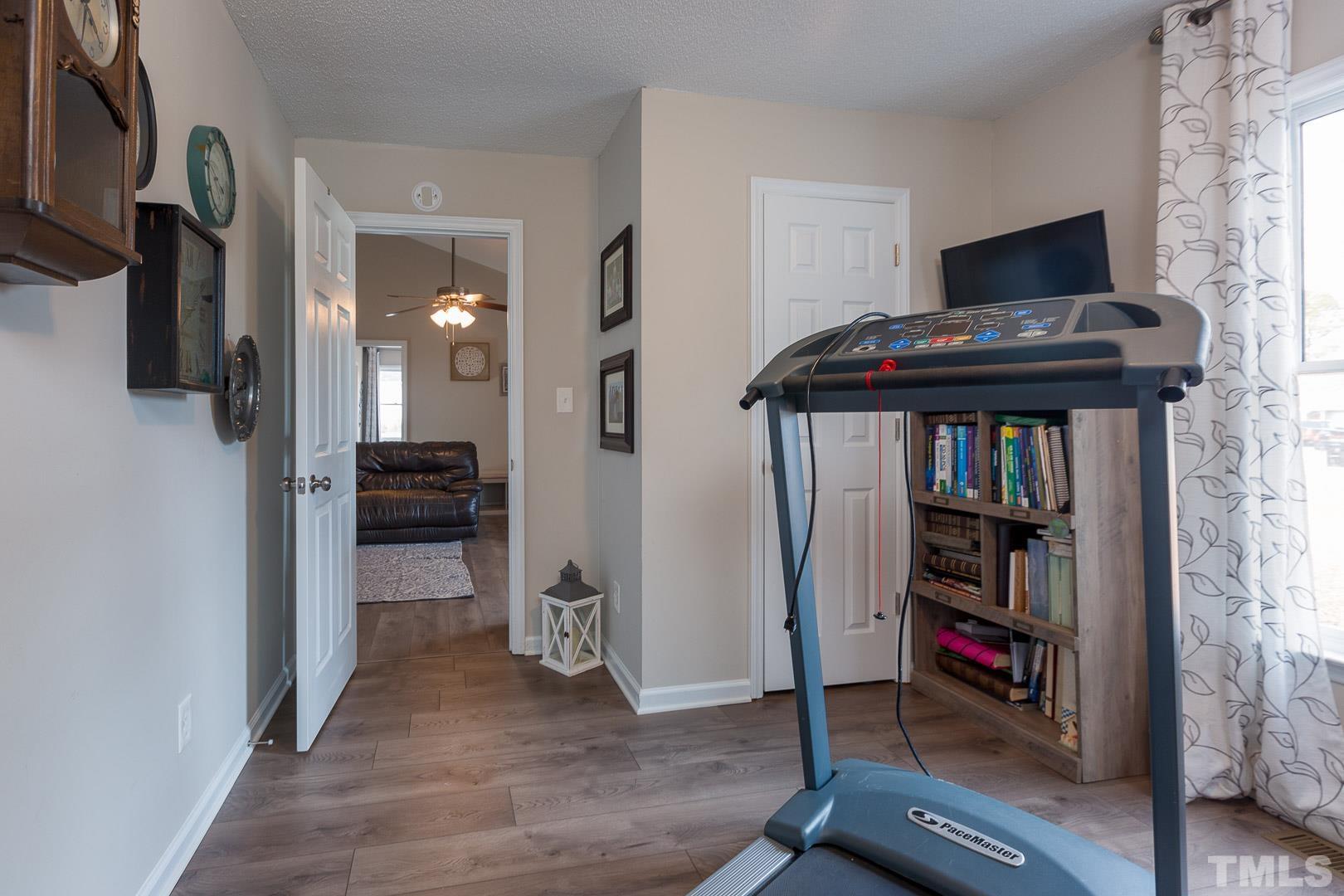 1558 Langdon Road Angier, NC 27501 - Photo 21 of 25 a living room with furniture and a book shelf