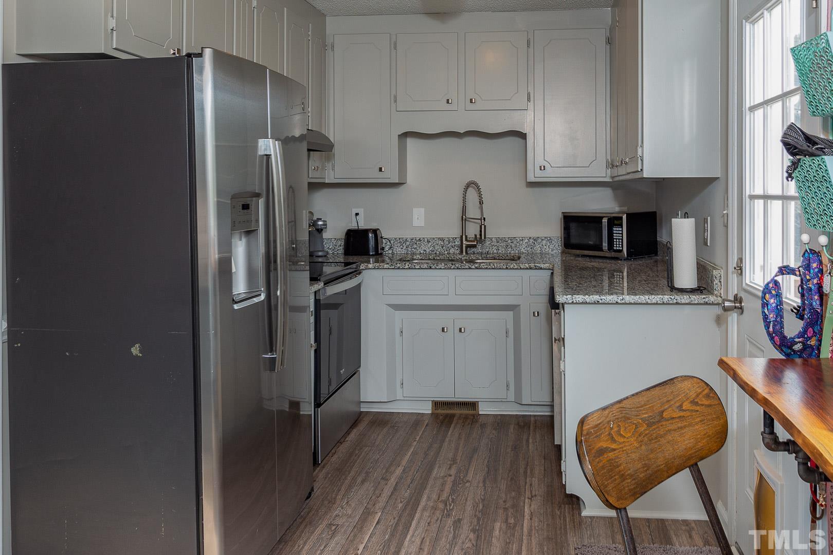 1558 Langdon Road Angier, NC 27501 - Photo 9 of 25 a kitchen with stainless steel appliances granite countertop a refrigerator and a stove top oven