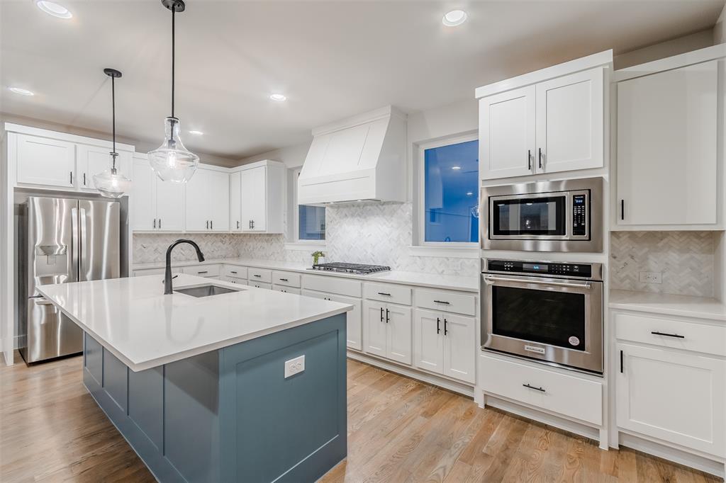 1144 Lavender Ridge Dallas, TX 75204 - Photo 4 of 18 a kitchen with kitchen island a sink stainless steel appliances and cabinets