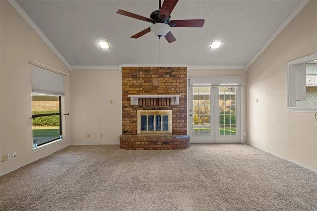 a view of an empty room with a fireplace and a window