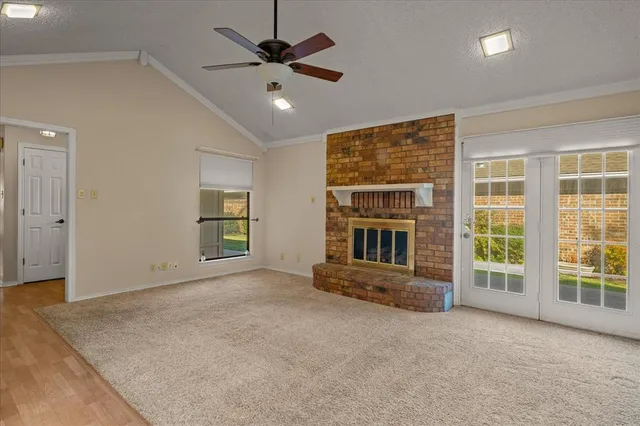 an empty room with windows and ceiling fan
