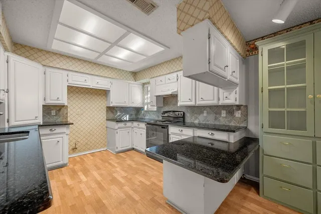 a kitchen with stainless steel appliances granite countertop a stove sink and cabinets