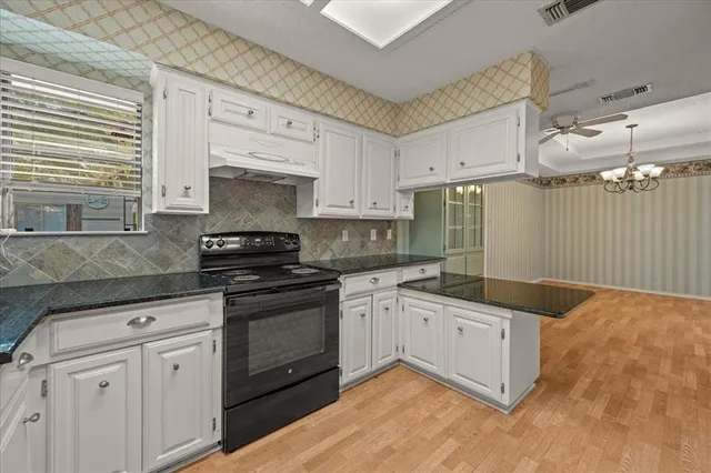 a kitchen with granite countertop a sink stove and cabinets
