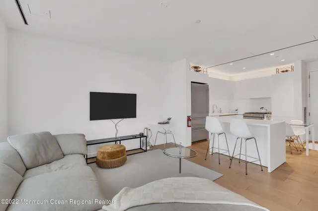a living room with furniture and view of kitchen