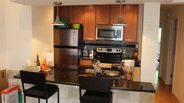 a kitchen with a refrigerator and a stove top oven
