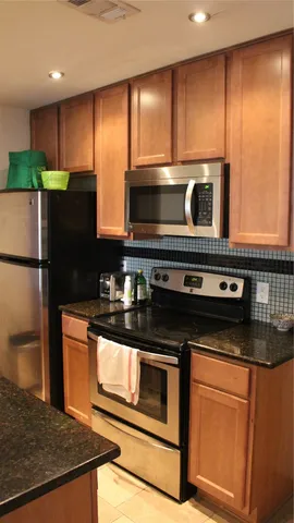 a kitchen with stainless steel appliances granite countertop a stove a microwave and a refrigerator