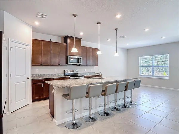 a kitchen with kitchen island a dining table chairs and a sink