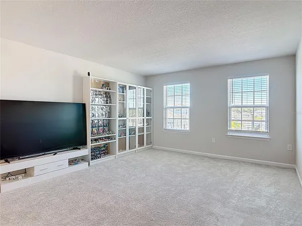 an empty room with windows and flat screen tv