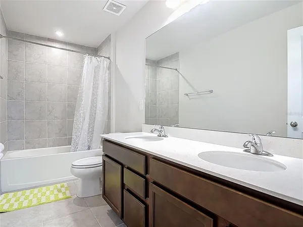 a bathroom with a double vanity sink toilet and a bathtub