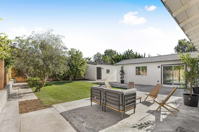 a backyard of a house with table and chairs