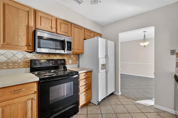 a kitchen with granite countertop a refrigerator stove and microwave