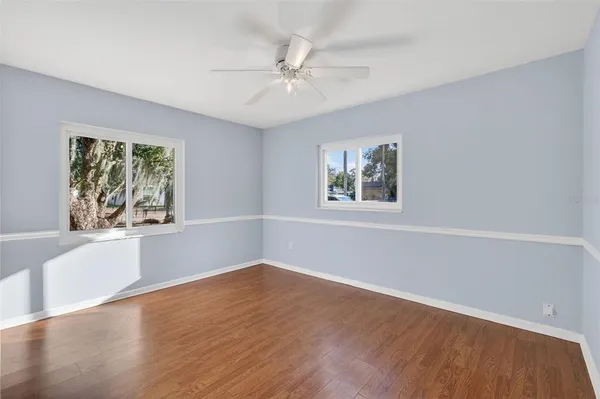 a view of a big room with wooden floor and windows