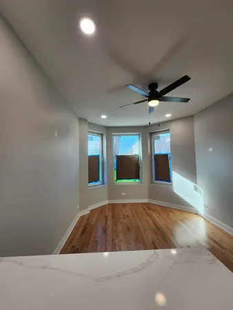 a large kitchen with kitchen island a sink dishwasher a refrigerator and a stove with wooden floor