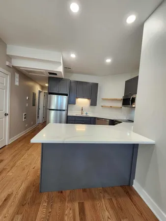 a large kitchen with stainless steel appliances granite countertop a stove a sink and a refrigerator