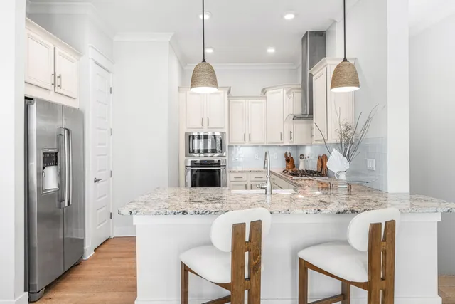 a kitchen with kitchen island granite countertop a sink a center island stainless steel appliances and cabinets