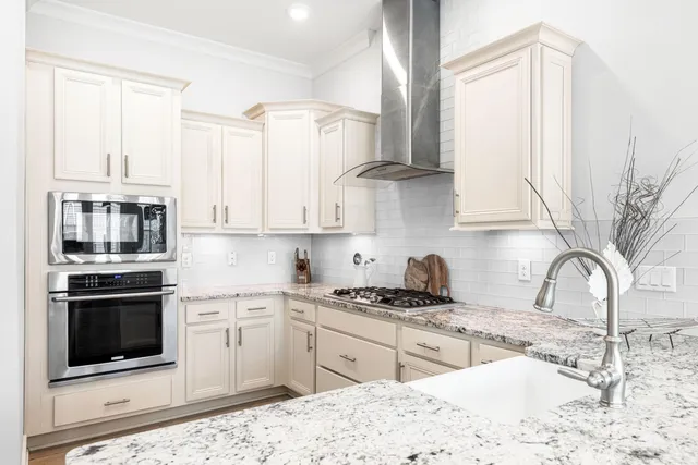 a kitchen with white cabinets and appliances