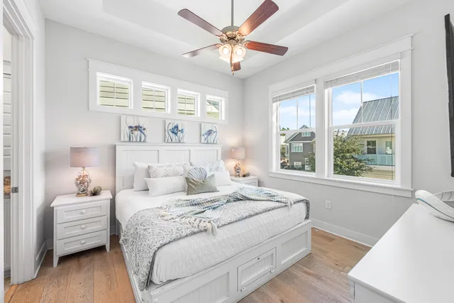 a bedroom with a bed a flat tv screen and a chandelier