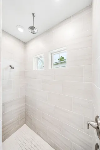 a spacious bedroom with a large bed and a flat tv screen