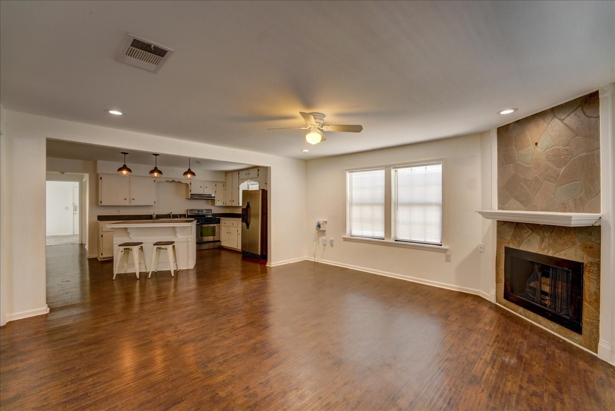1105 East 3rd Street Austin, TX 78702 - Photo 2 of 40 a view of an empty room with a fireplace and wooden floor