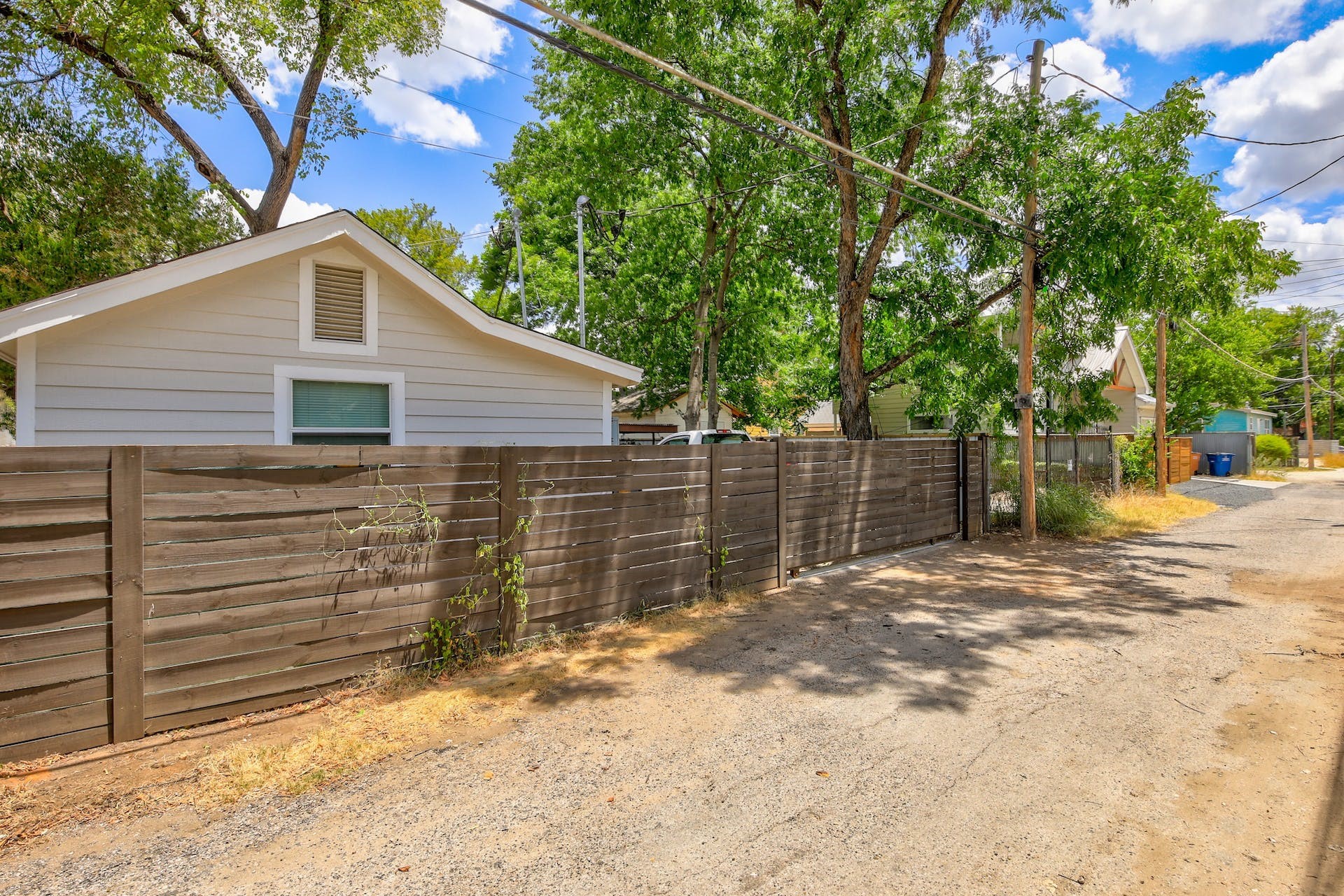 1105 East 3rd Street Austin, TX 78702 - Photo 33 of 40 a backyard of a house with large trees and a wooden fence