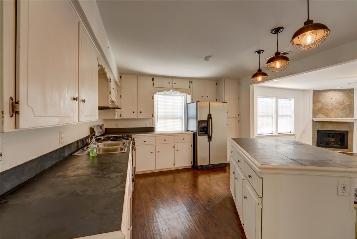 1105 East 3rd Street Austin, TX 78702 - Photo 7 of 40 a kitchen with a stove a sink and a refrigerator