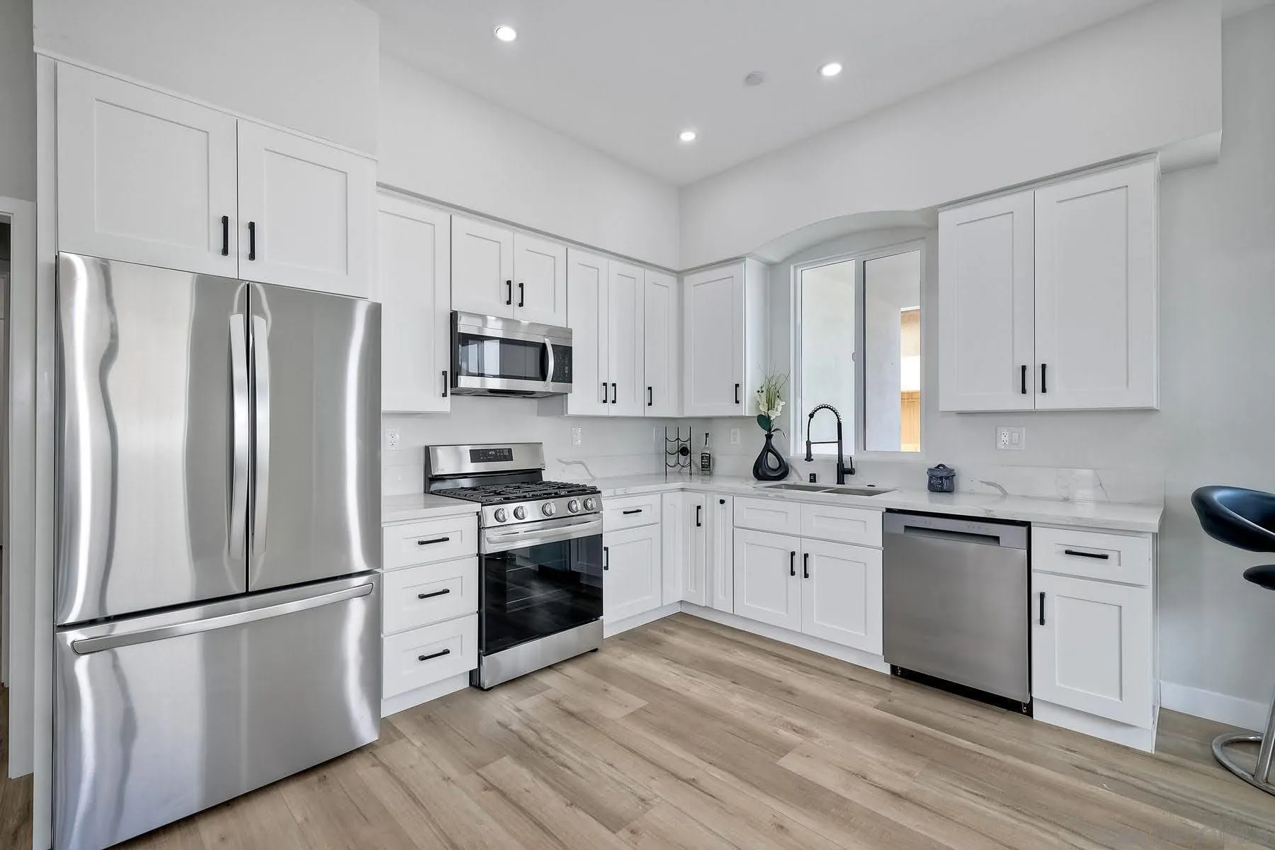 573 Florida Street Imperial Beach, CA 91932 - Photo 23 of 37 a kitchen with white cabinets and stainless steel appliances