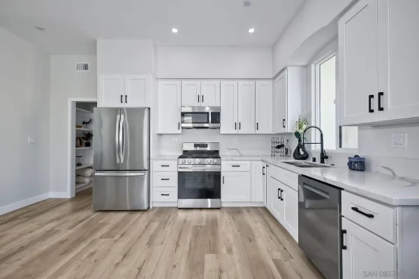 a kitchen with cabinets stainless steel appliances and a window