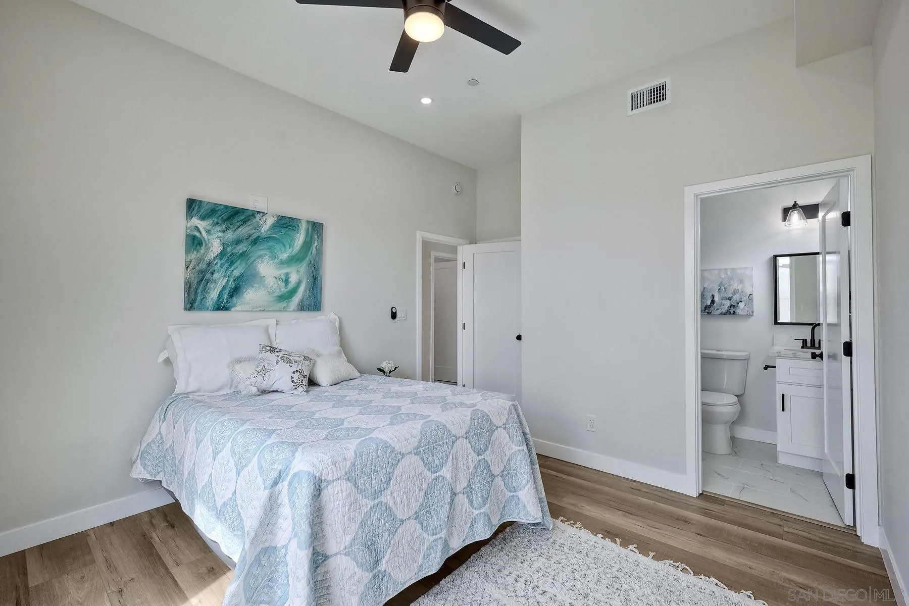 573 Florida Street Imperial Beach, CA 91932 - Photo 27 of 37 a bedroom with a large bed and a chandelier