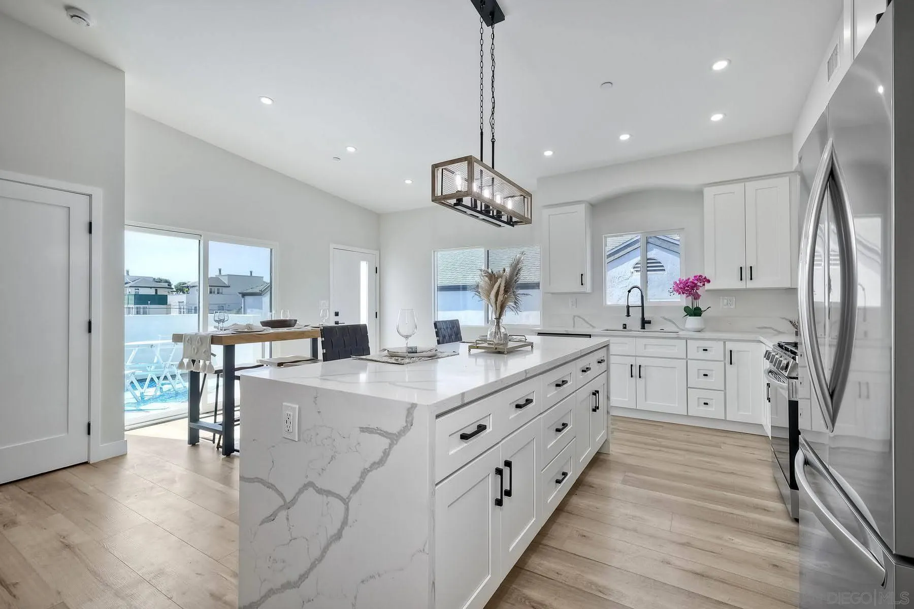 573 Florida Street Imperial Beach, CA 91932 - Photo 5 of 37 a kitchen with stainless steel appliances kitchen island granite countertop a table chairs and a refrigerator