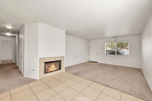 an empty room with windows and fireplace