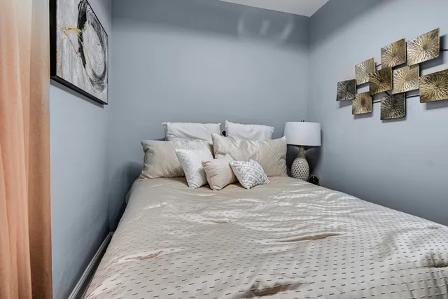 a large bed sitting in a bedroom next to a window