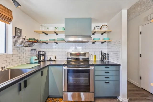 a kitchen with stainless steel appliances granite countertop a sink and a stove