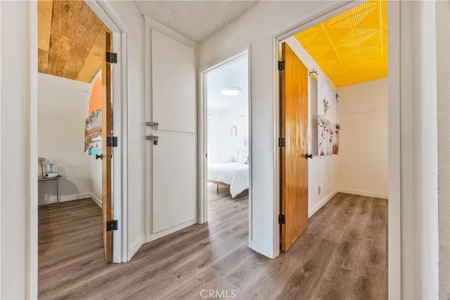 a view of a hallway with wooden floor and a living room