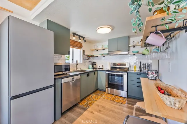 a kitchen with stainless steel appliances granite countertop a stove a sink and a refrigerator
