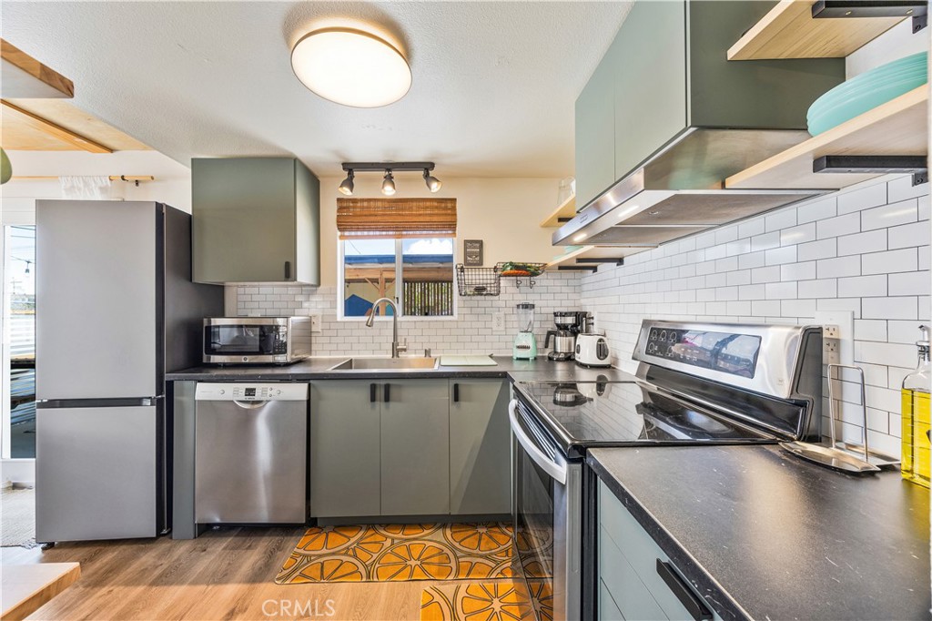 6123 Scenic Drive Joshua Tree, CA 92252 - Photo 10 of 30 a kitchen with stainless steel appliances granite countertop a sink stove and refrigerator