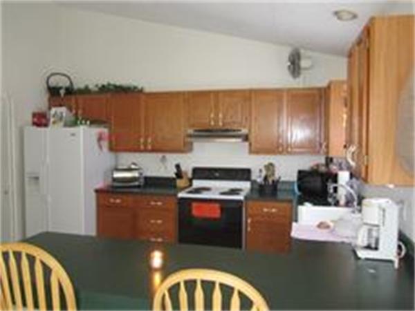 61 Round House Road, Unit 61 Bourne, MA 02532 - Photo 5 of 7 a kitchen with stainless steel appliances granite countertop a stove refrigerator sink and cabinets