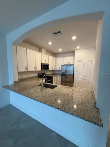 a kitchen with stainless steel appliances granite countertop a refrigerator sink and cabinets