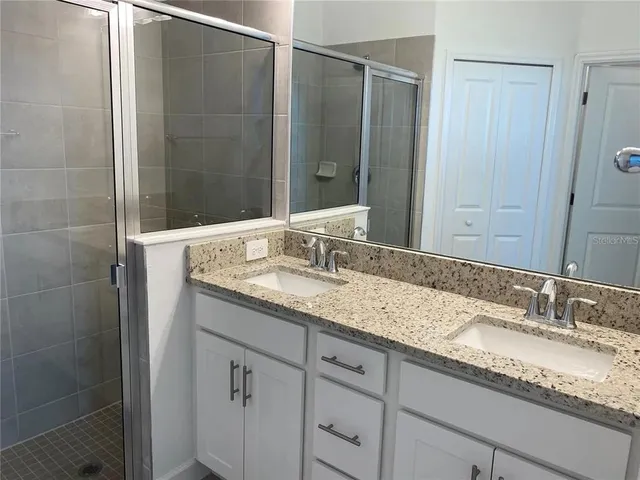 a bathroom with a granite countertop sink and a mirror