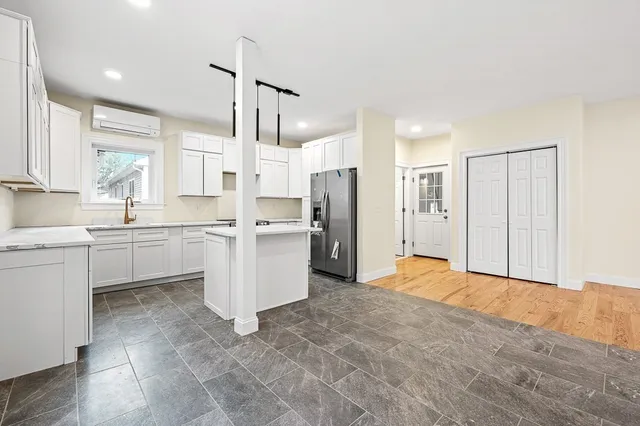 a large white kitchen with white cabinets and stainless steel appliances