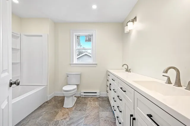 a bathroom with a double vanity sink toilet and shower