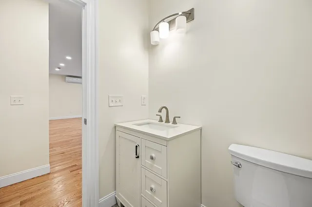 a bathroom with a toilet a sink and mirror